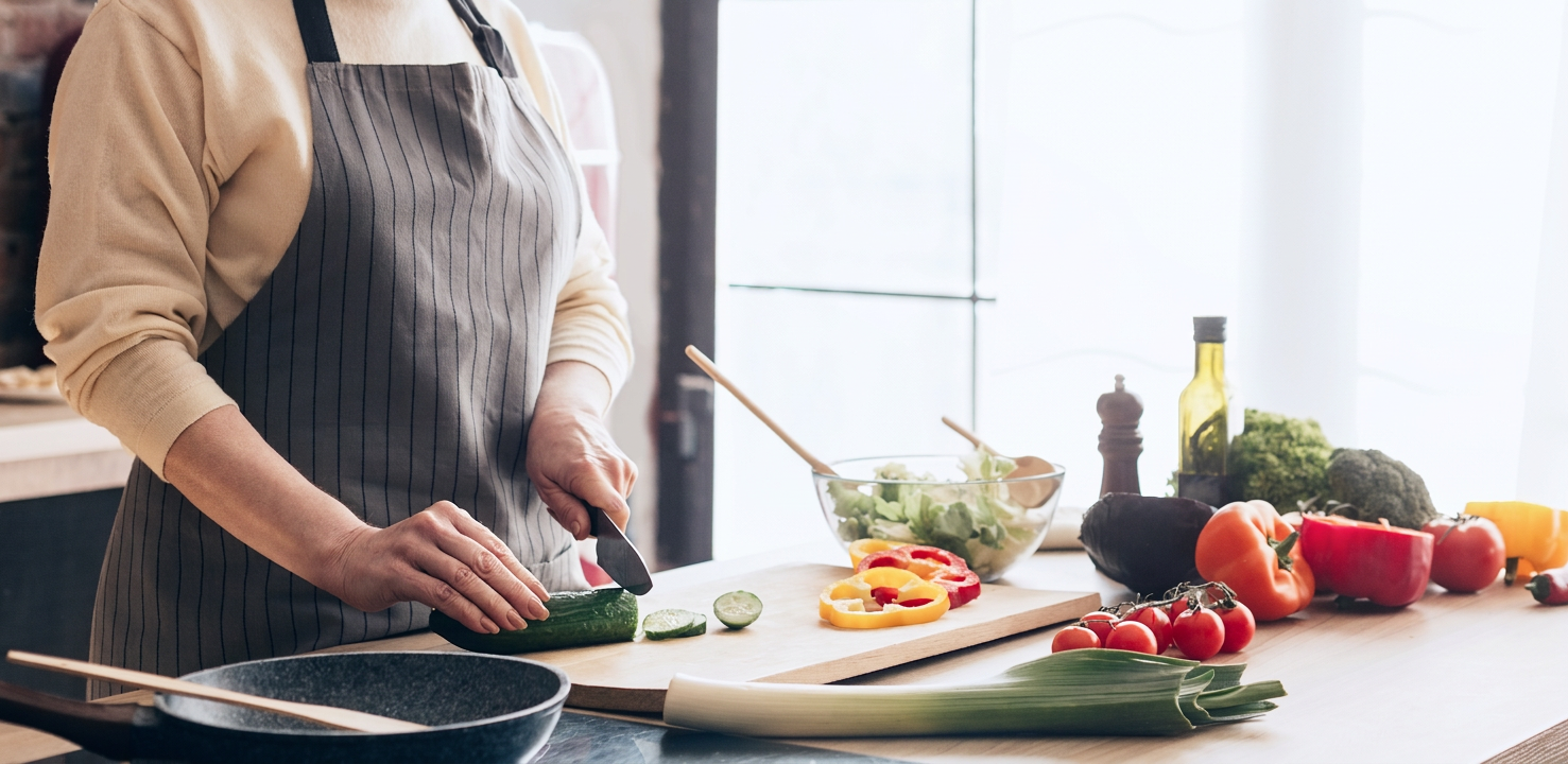 person in kitchen cutting vegetables